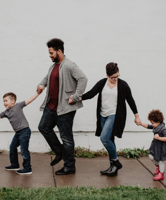 Une image de quatres personnes, deux adultes et deux enfants, qui se tiennent la main. Symbolise l'importance de l'humain pour l'entreprise Insure.